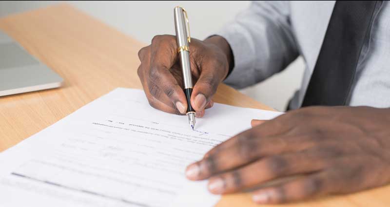 Person Writing a Contract